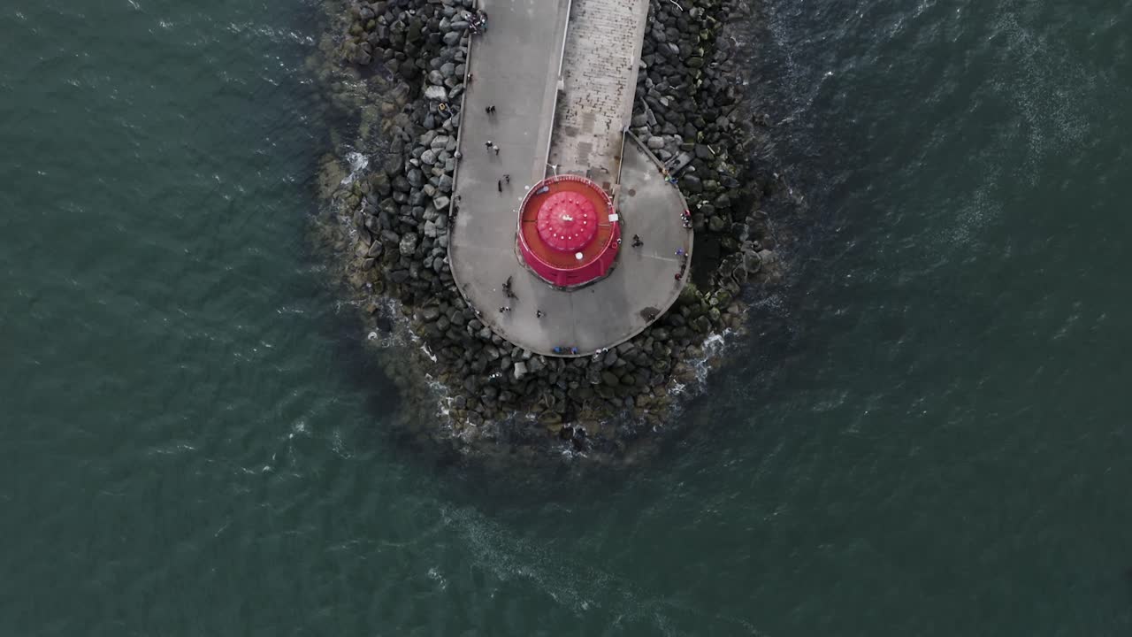 vista de arriba hacia abajo de personas caminando alrededor del faro poolbeg