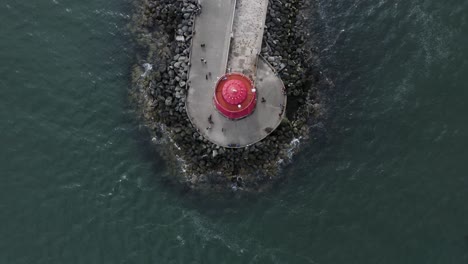 Blick-Von-Oben-Nach-Unten-Vorbeifliegen-Von-Menschen,-Die-Um-Den-Poolbeg-Leuchtturm-Herumgehen