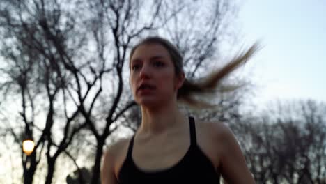 caucasian active woman running through city park, low angle close up