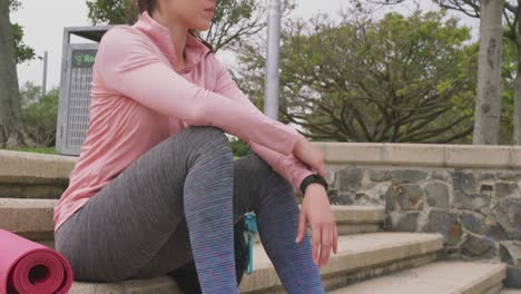 Caucasian-woman-sitting-with-a-yoga-mat