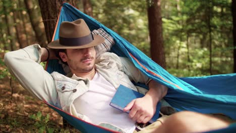 hombre relajándose en una hamaca en el bosque