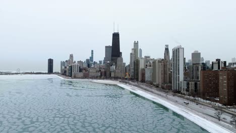 aerial view over ice, around the near north side skyline, winter in chicago, usa