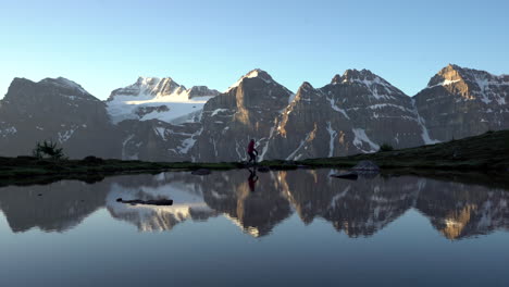 Excursionista-Camina-A-Lo-Largo-De-Las-Costas-Glaciales-Canadienses-Con-Reflejos-En-El-Lago-Quieto