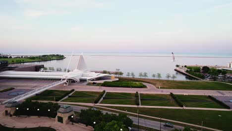 pájaro entra en el cuadro mientras filma sobre milwaukee wisconsin centro de la ciudad - puesta de sol aérea