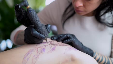 Tatuador-Aplicando-Tatuaje-En-La-Cadera-De-Una-Mujer-Anónima-En-La-Tienda