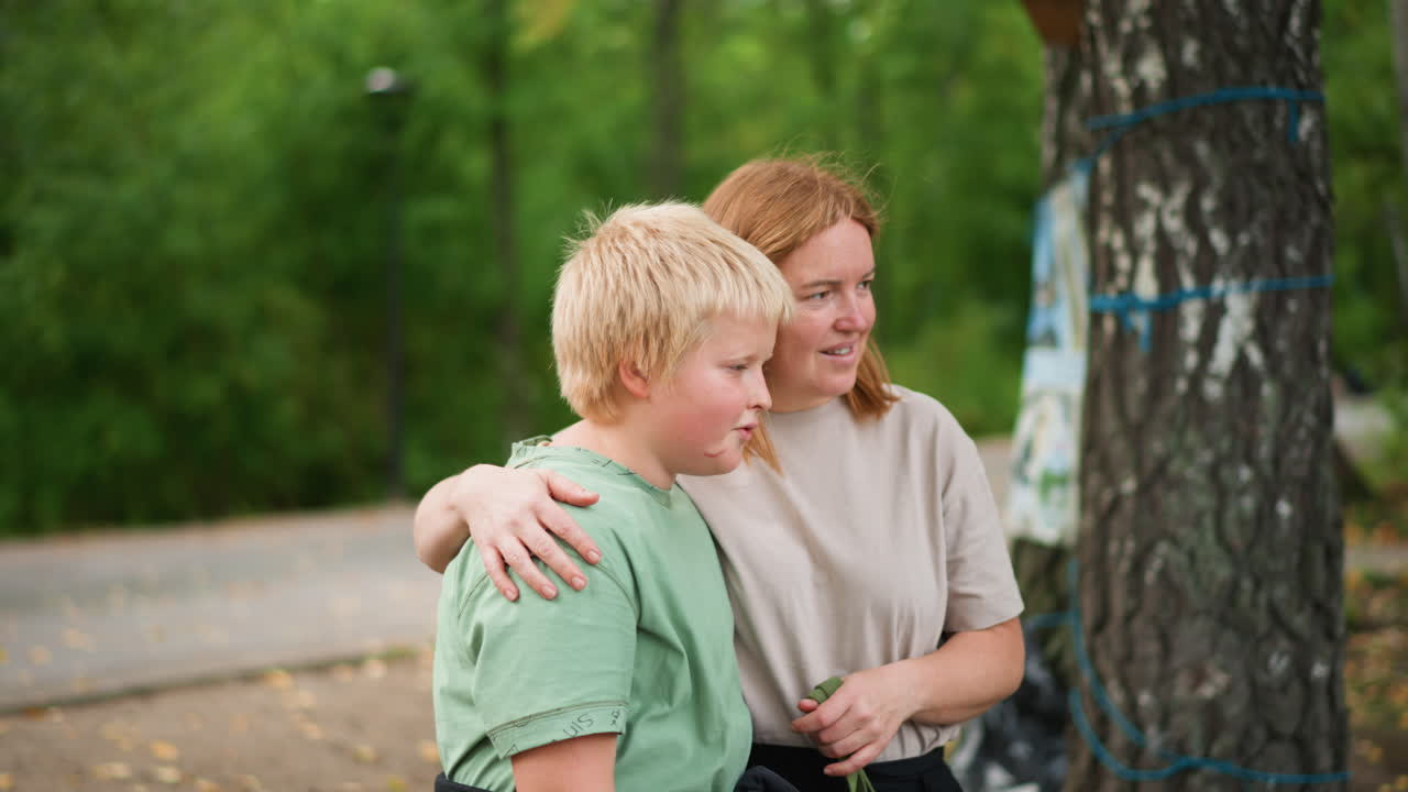 Gentle Embrace Amid Wooden Surroundings, Warm Interaction Between Mother And Son In Forest Setting, Parent Lovingly Holds Child Close During Exploration In Peaceful Woodland Environment