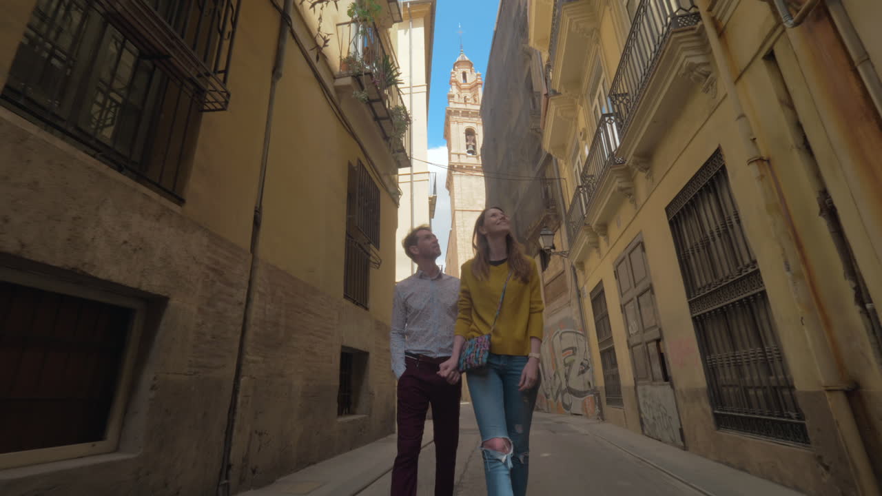 Una coppia sorridente che cammina su una bellissima strada di Valencia