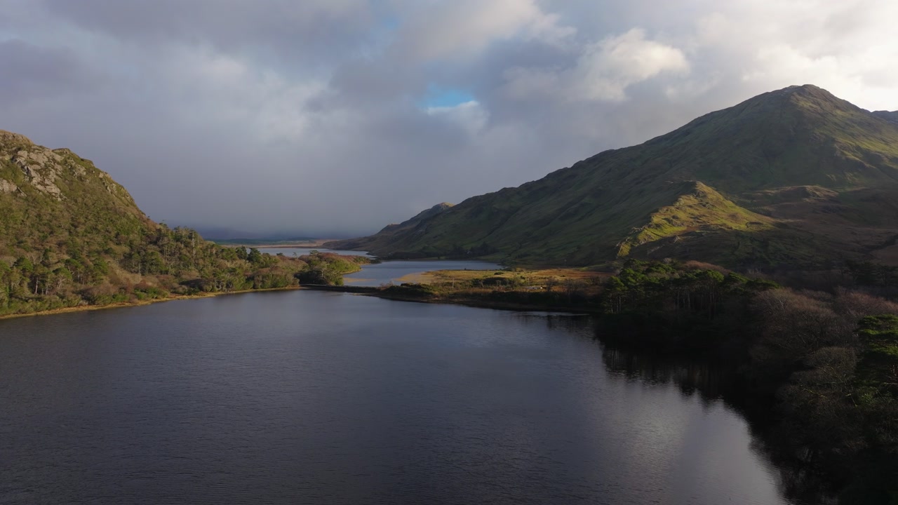 4K Cinematic Drone footage of Kylemore featuring calm water, mountain backdrop, and clear sunny conditions. Scenic and peaceful Irish landscape_09