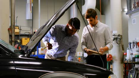 engineers examining car engine in workshop 4k