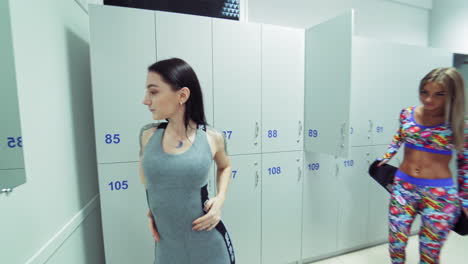 women getting ready for training. view of girls posing in locker room of fitness center