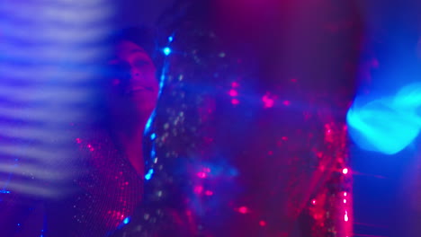 close up of two women in nightclub bar or disco dancing with sparkling lights 6