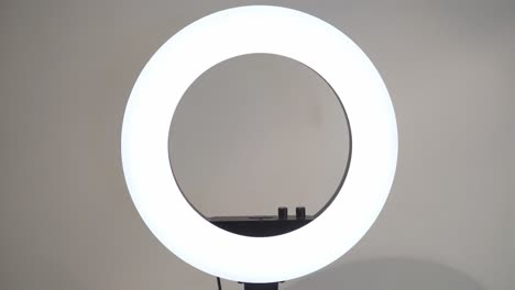 encendiendo la lámpara de anillo led blanca en el estudio.