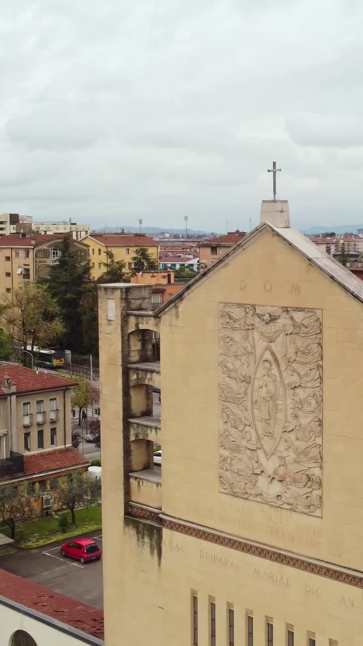 Vertical truck shot of Parrocchia Santuario Cuore Immacolato di Maria - Tempio Votivo with bustling Italian traffic around it.