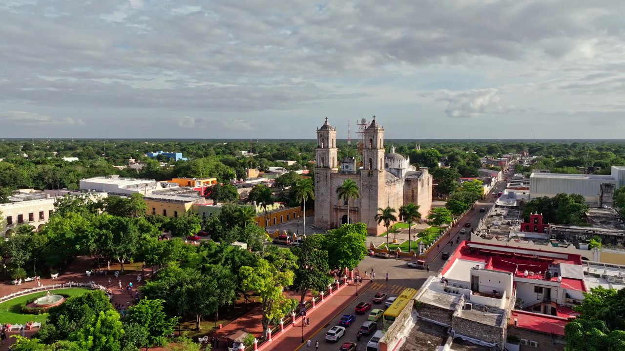 Meksika, Yucatan, Valladolid'deki San Bernardino de Siena Kilisesi ve çan kulesinin havadan görünümü, etrafında kümelenmiş kırmızı çatılı kolonyal binalarla birlikte.
