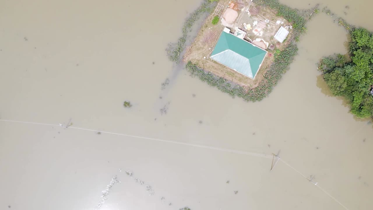 Rural village submerged by flood water in South Asia. Aerial top down shot