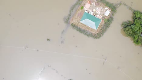 rural village submerged by flood water in south asia. aerial top down shot