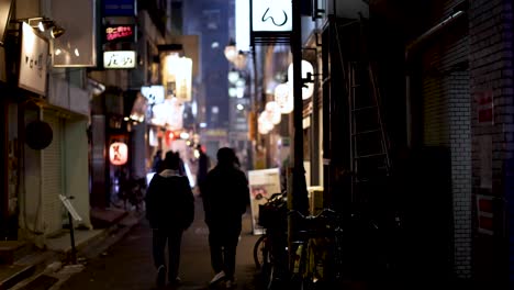 silhouetted figures walking down an illuminated street