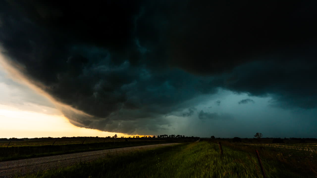 Dramatisk storm bevæger sig hen over marker og landbrugsjord med kraftig vind og regn