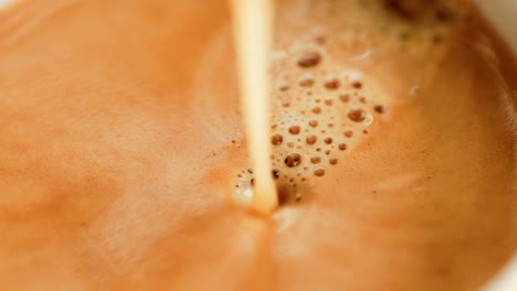 pouring espresso into a cup