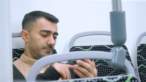 hombre usando teléfono móvil en un autobús