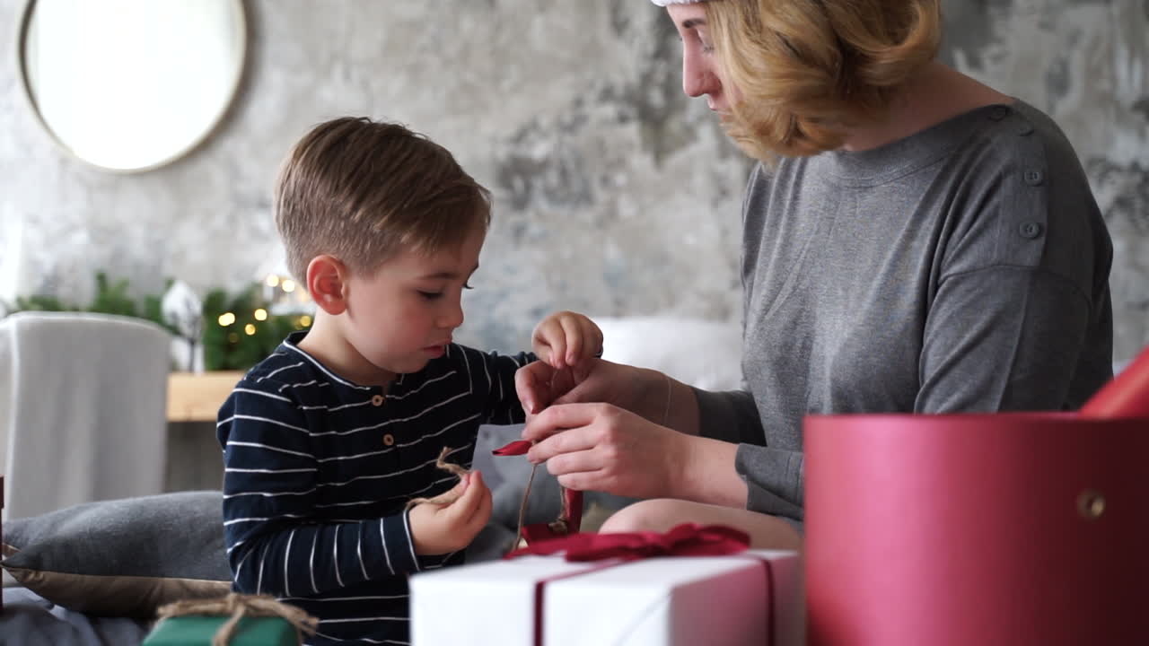 madre e hijo preparan cintas de regalos de navidad 1