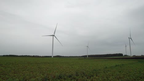 cinematic shot of windmills in windmill farm producing alternative energy - dolly shot