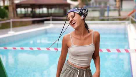 happy woman dancing by a pool