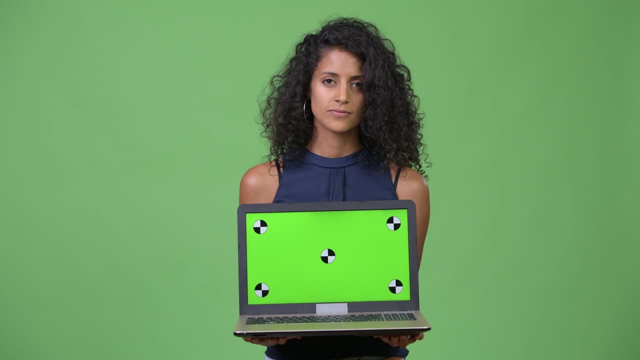 Young beautiful Hispanic businesswoman showing laptop