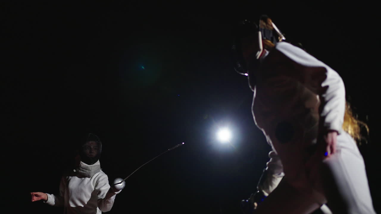 dos mujeres esgrimistas compiten en un partido