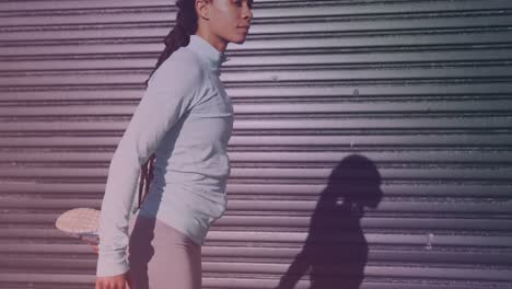 african american fit woman in sportswear stretching her leg by the street