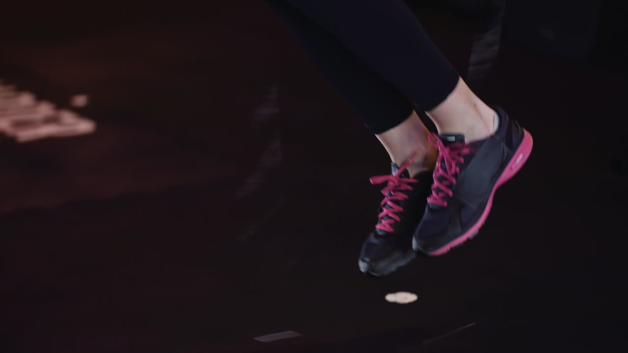 체육관에서 체력 훈련을 하는 줄넘기를 사용하는 스포티한 여성의 낮은 부분