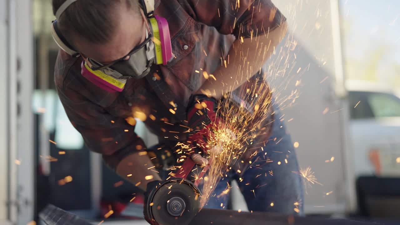 Professional craftsman worker grinding metal with flying sparks, slowmo