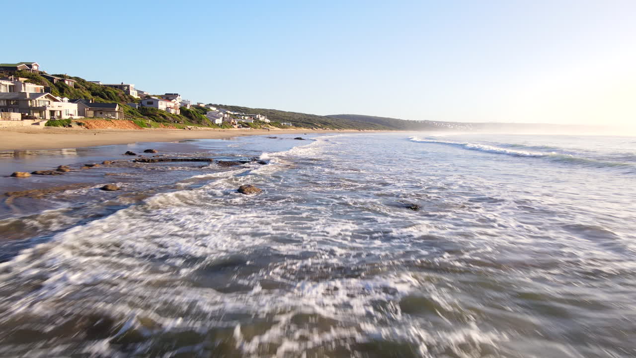 Lågt flygfoto över klippor och vågor som rullar in mot Vleesbaai-stranden, Sydafrika