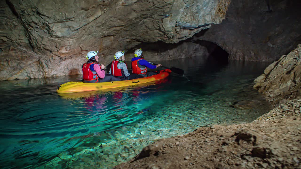 Three Women Kayak Through Underground Cave Across Turquoise Water