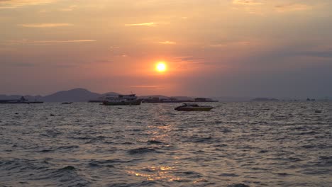 gorgeous fire sunset over the sea and the silhouette of jetski riding