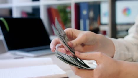 mano de mujer contando billetes de dólar en la oficina. manos femeninas contando dinero dólares