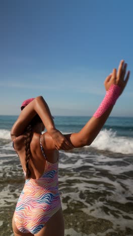 mujer estirándose en la playa
