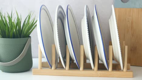 estante de platos de bambú con placas blancas y azules