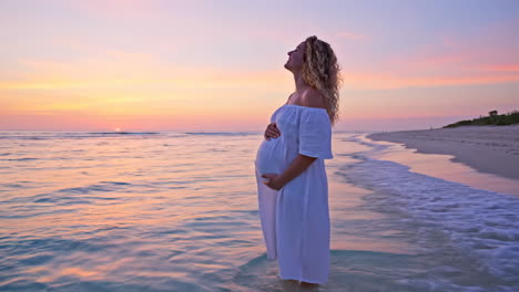 pregnant woman on the beach at sunset