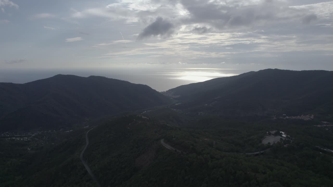 fascinante video grabado sobre los pinos voladores del paso de bracco en italia, en el fondo el mar y la playa de deiva marina