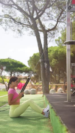 a woman exercising with a cable machine at an outdoor gym