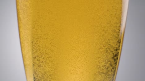 primer plano, burbujas de cerveza en cámara lenta, bebida líquida dorada fresca