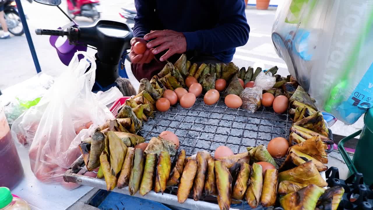 vendedor preparando arroz pegajoso a la parrilla y huevos hervidos