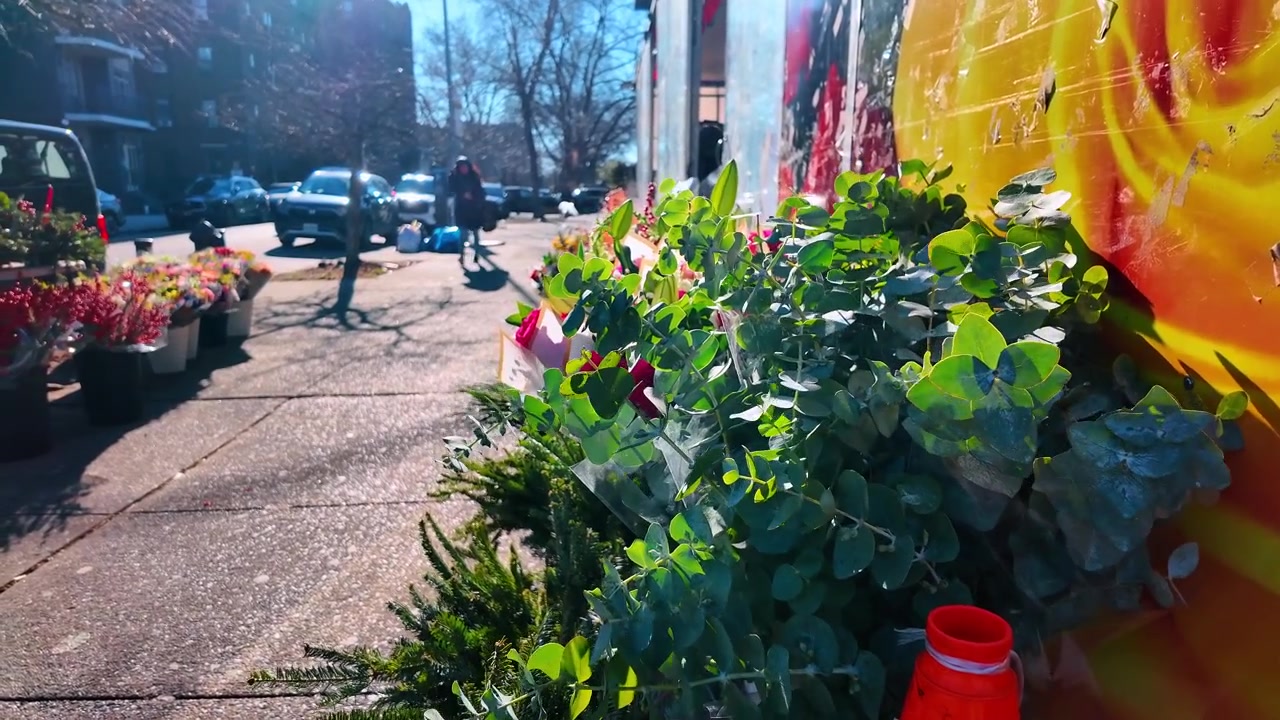 New York, USA, 12. januar 2026: Blomsterbuketter og eukalyptus på et byfortau. Friskt grønt løvverk står utenfor en butikk ved siden av et levende gult blomsterveggmaleri på en solrik dag