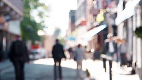 general view of people walking in a city street on sunny day,  defocussed