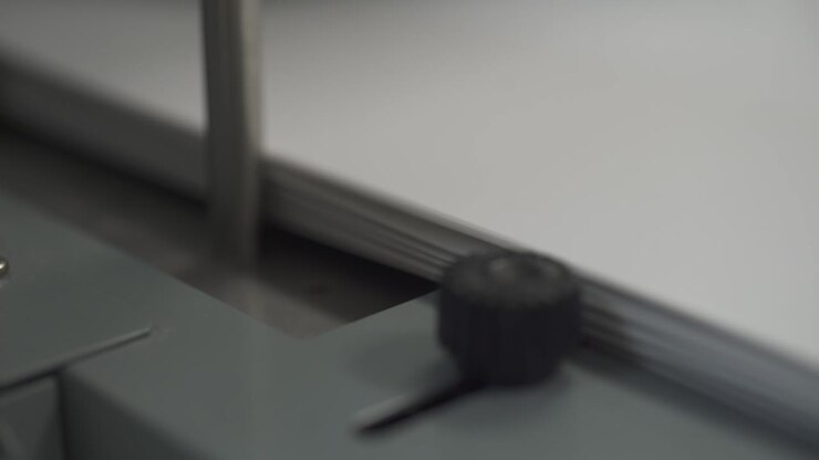 An industrial printer passes paper and film