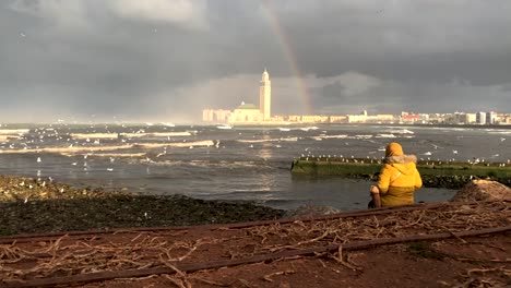 una joven marroquí admirando la vista de casablanca con el arco iris