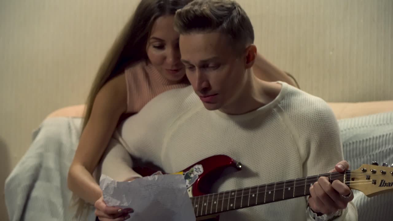 pareja tocando la guitarra juntos en casa