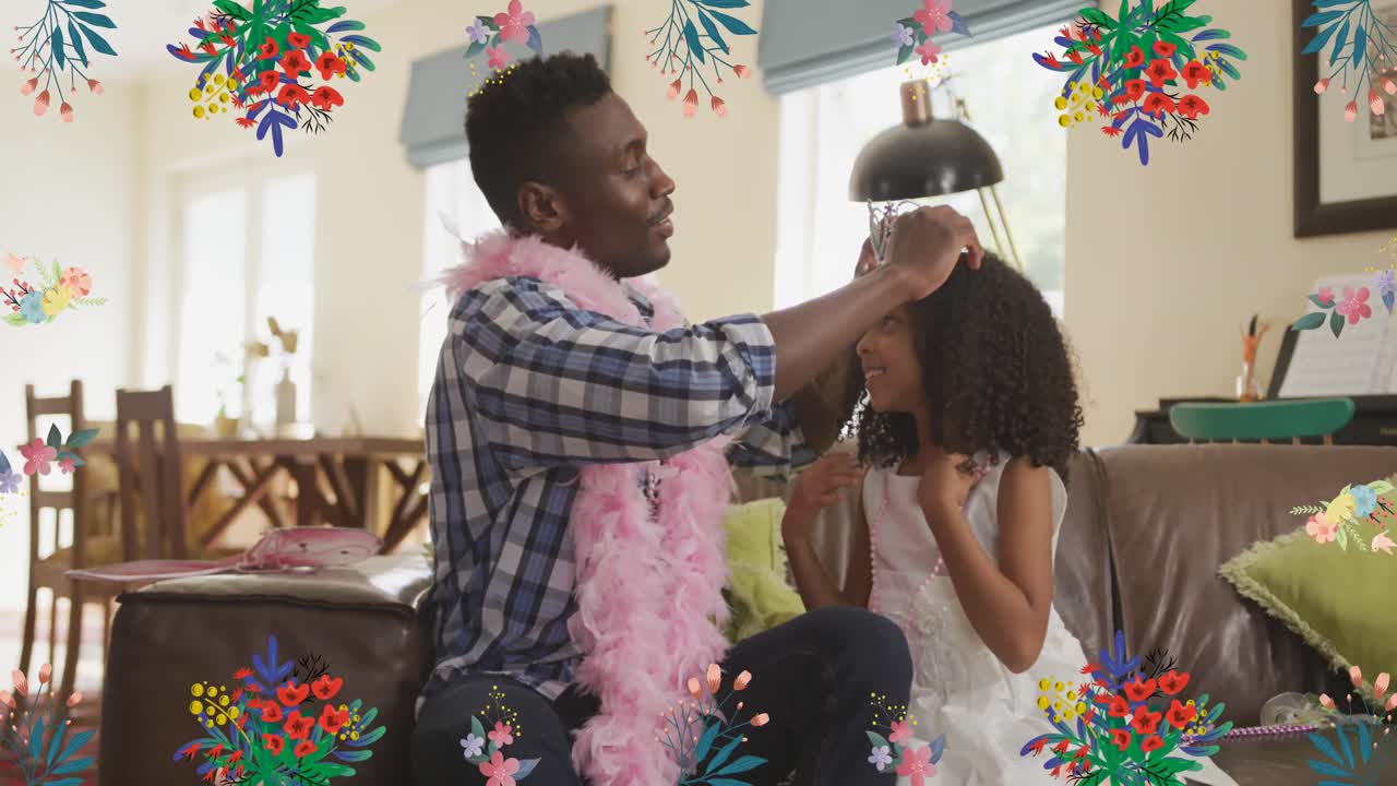 Animação de flores sobre pai afro-americano feliz colocando coroa na filha em casa