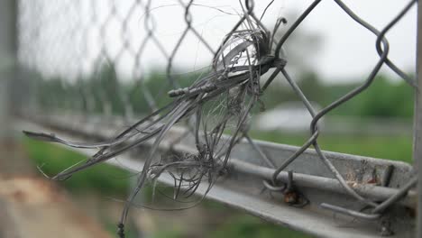 close up of the rope blowing in the wind on the road guardrail wire